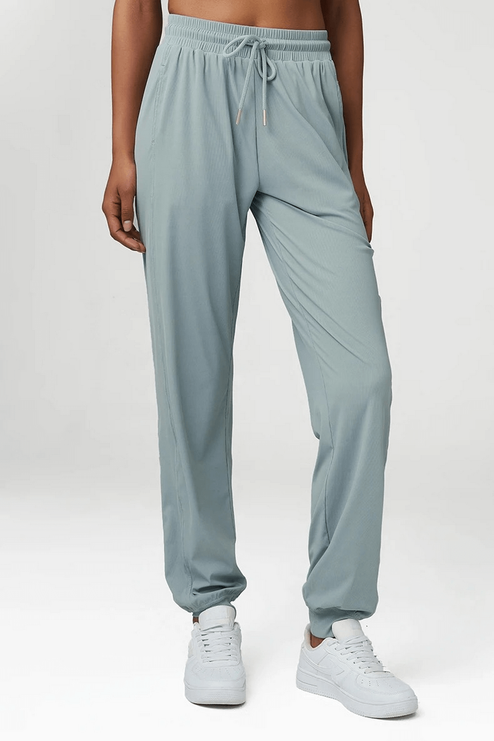 Women's breathable drawstring jogger pants in light green, perfect for casual or sporty looks. Comfort fit with nylon-spandex blend.